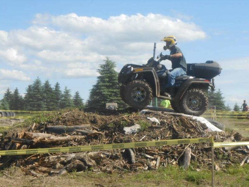 Rider on quad ATV going over a mound of debris at Tall Pines ATV Park