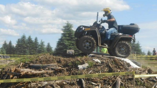 Rider on quad ATV going over a mound of debris at Tall Pines ATV Park